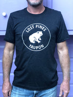 Black shirt with white Lost Pines Yaupon tea logo. Frog with the words Lost Pines above and Yaupon below.
